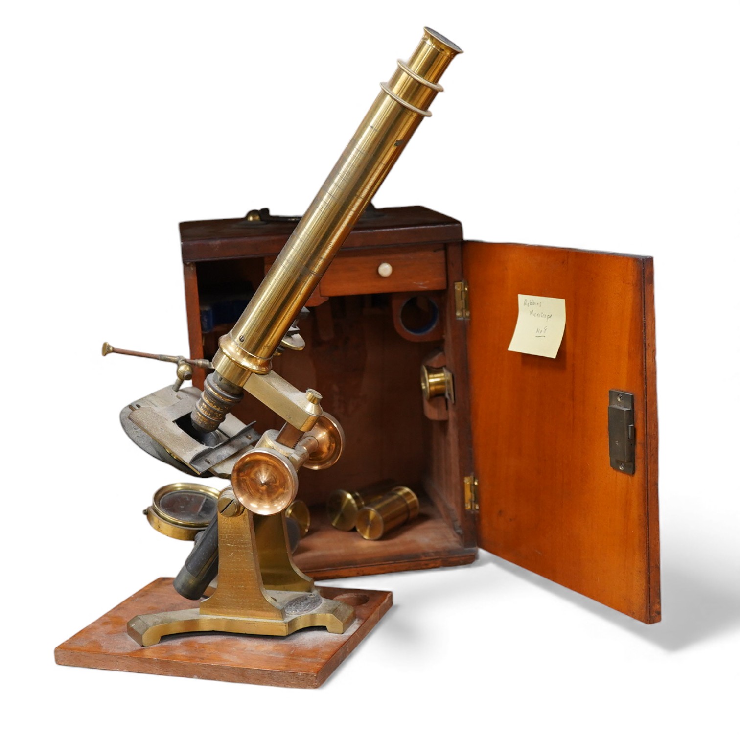 A mid 19th century brass compound monocular microscope, by J & C Robbins, 9, Bartholomew Close, London, with accessories and various slides, raised on a wooden base, the case 25cm high